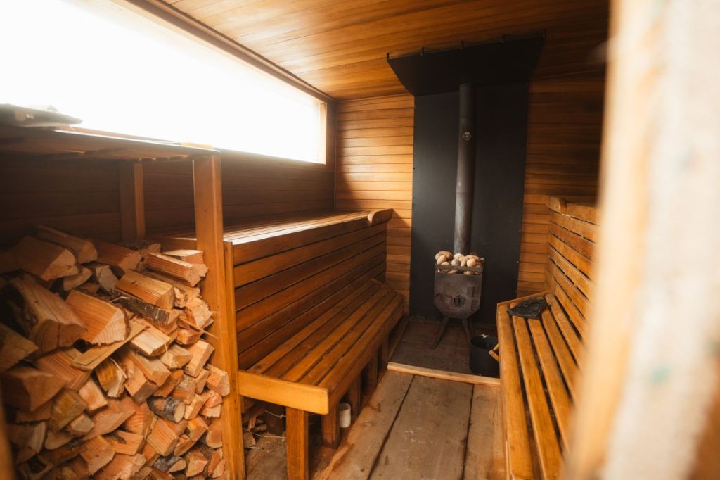 The Art of Drawing Readers In: Your attractive post title goes here Warm wooden sauna interior with benches and fireplace, offering a relaxing and inviting atmosphere.