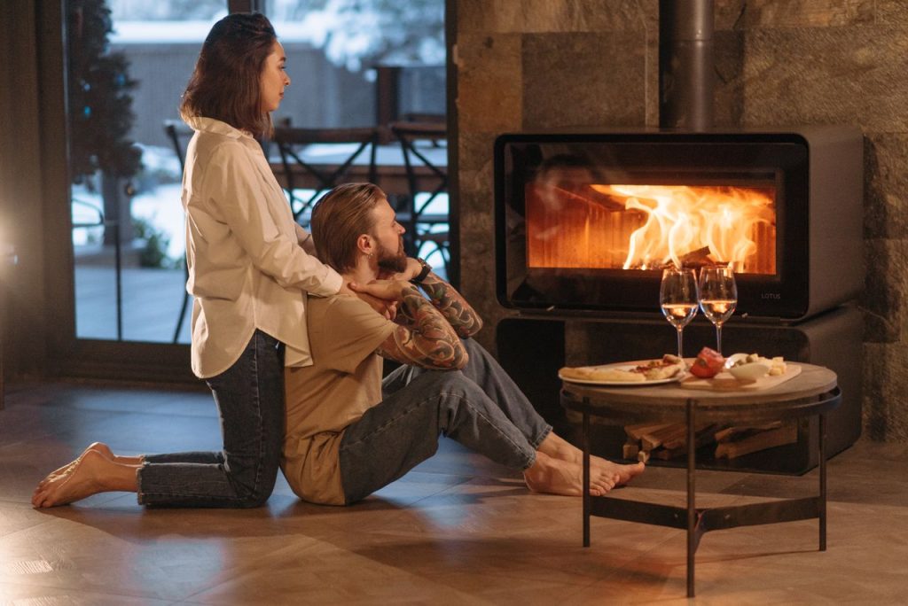 Mastering the First Impression: Your intriguing post title goes here A couple relaxing by a warm fire with wine and snacks, creating a cozy winter mood.